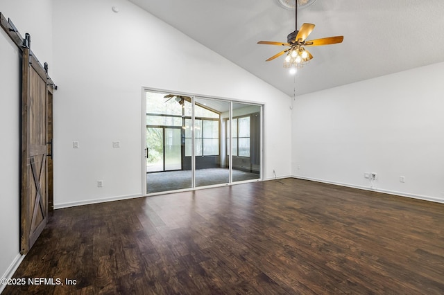 spare room with ceiling fan, dark wood-type flooring, high vaulted ceiling, and a barn door