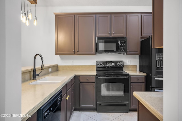 kitchen featuring light tile patterned floors, black appliances, pendant lighting, dark brown cabinetry, and sink