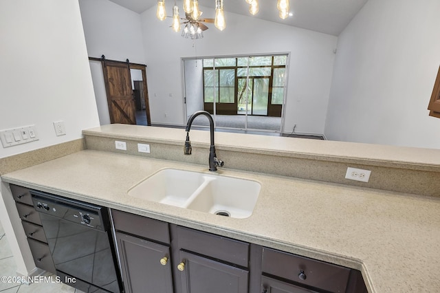 kitchen with a barn door, black dishwasher, lofted ceiling, pendant lighting, and sink