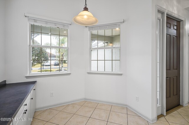 unfurnished dining area with light tile patterned flooring