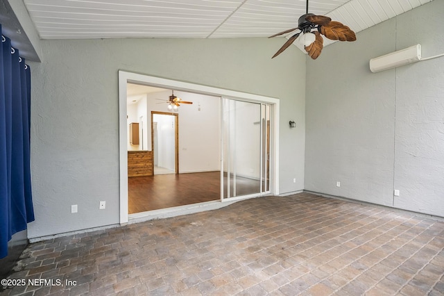 unfurnished room featuring an AC wall unit and vaulted ceiling