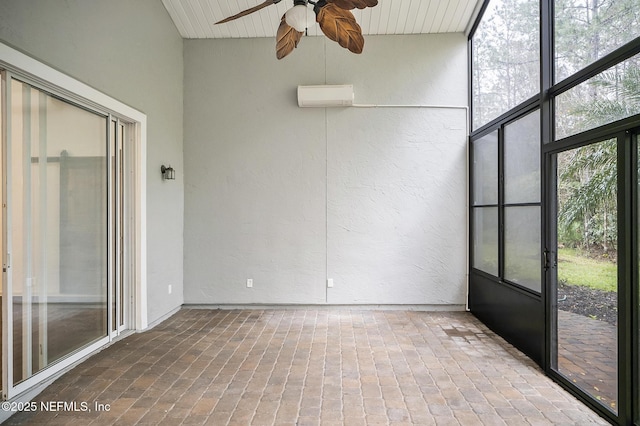 unfurnished sunroom featuring an AC wall unit, plenty of natural light, and ceiling fan