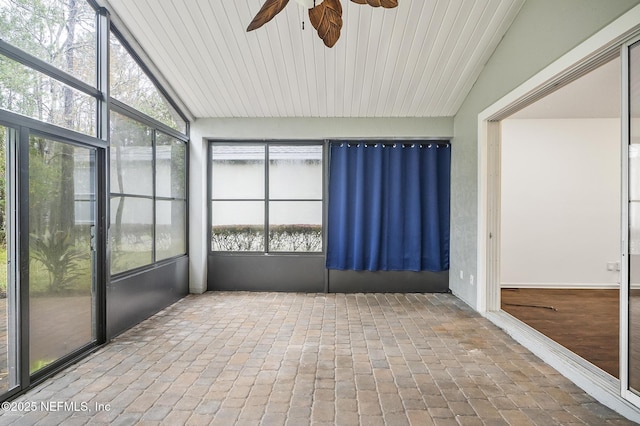 unfurnished sunroom featuring ceiling fan and vaulted ceiling