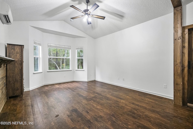 unfurnished living room featuring ceiling fan, vaulted ceiling, a wall unit AC, dark wood-type flooring, and a textured ceiling