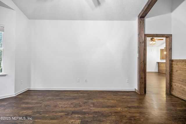 unfurnished room with a textured ceiling, ceiling fan, lofted ceiling, and dark hardwood / wood-style floors