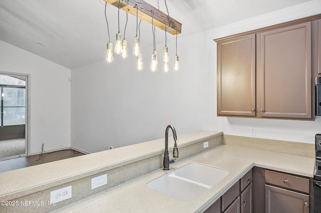 kitchen with sink, hanging light fixtures, and lofted ceiling