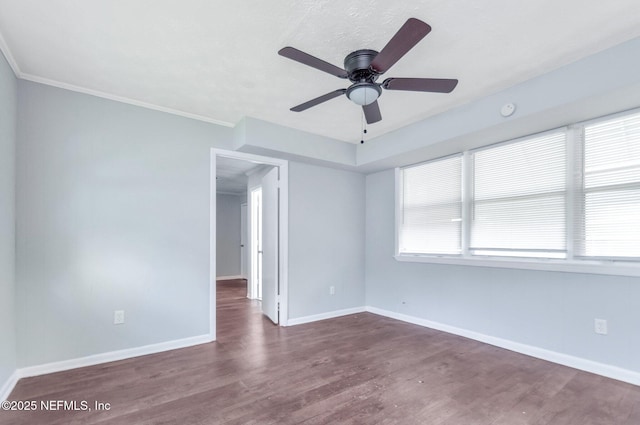 empty room with ceiling fan, dark hardwood / wood-style flooring, and crown molding