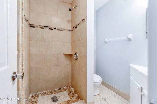 bathroom with toilet, a tile shower, tile patterned floors, and vanity