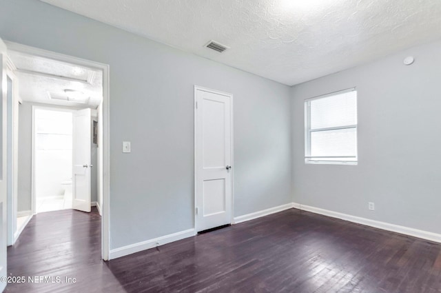 unfurnished room featuring a textured ceiling and dark wood-type flooring