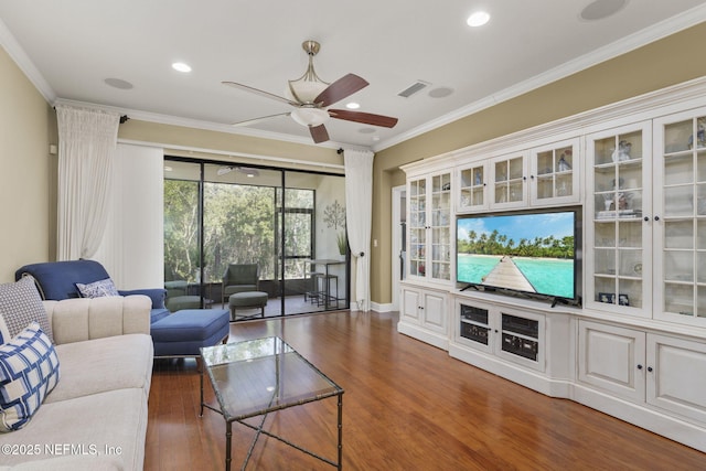 living room with crown molding, dark wood-type flooring, and ceiling fan