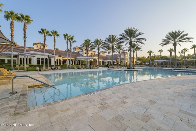 pool at dusk with a patio