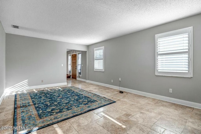 unfurnished room with a textured ceiling