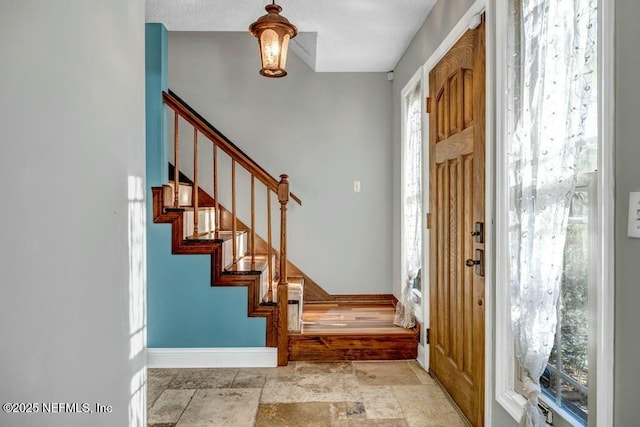 foyer entrance with a textured ceiling