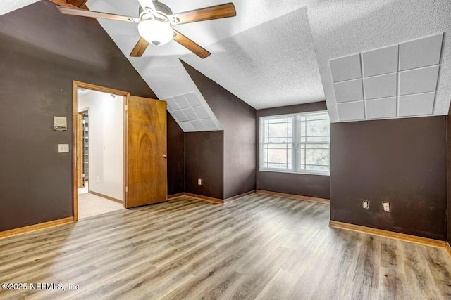 bonus room featuring ceiling fan, hardwood / wood-style floors, and vaulted ceiling