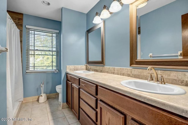 bathroom featuring toilet, vanity, a shower with curtain, and tile patterned floors