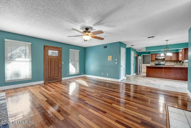 unfurnished living room with ceiling fan and light wood-type flooring