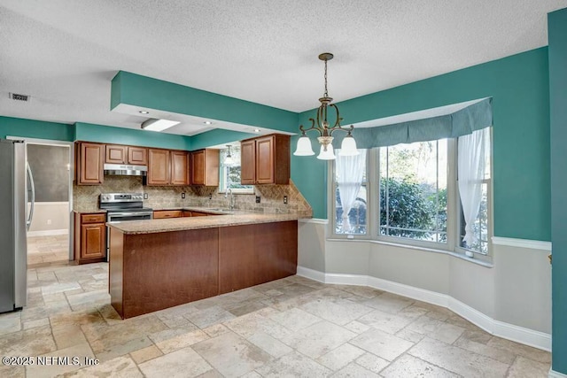 kitchen with plenty of natural light, stainless steel appliances, kitchen peninsula, and hanging light fixtures