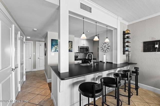 kitchen with sink, white cabinetry, hanging light fixtures, light tile patterned flooring, and kitchen peninsula