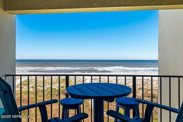 balcony with a water view and a beach view