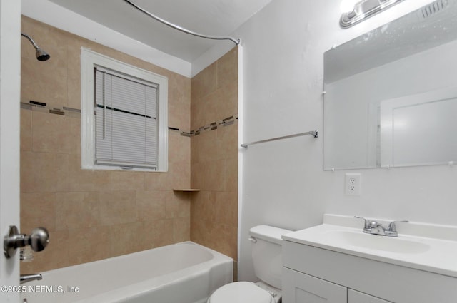 full bathroom featuring toilet, tiled shower / bath combo, and vanity