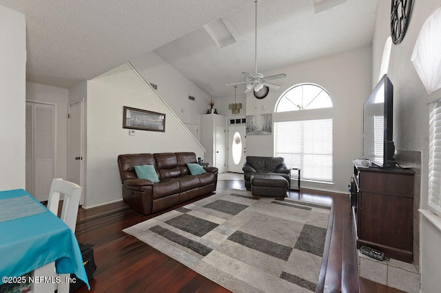 living room with ceiling fan, dark hardwood / wood-style flooring, high vaulted ceiling, and a textured ceiling