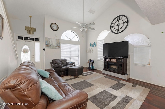 living room with a wealth of natural light, dark wood-type flooring, and high vaulted ceiling