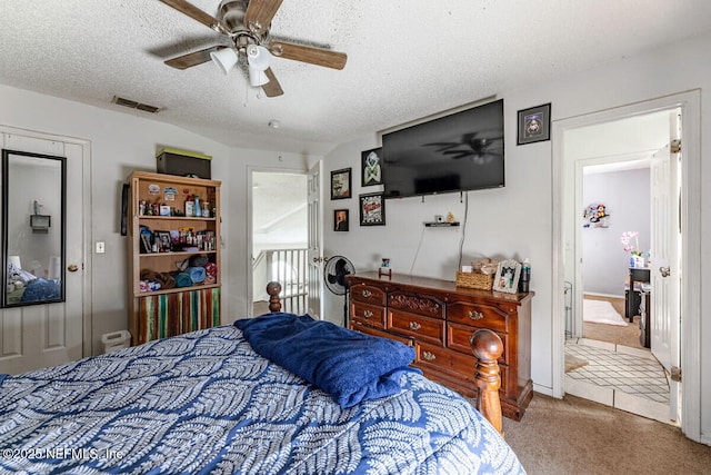 carpeted bedroom featuring a textured ceiling and ceiling fan