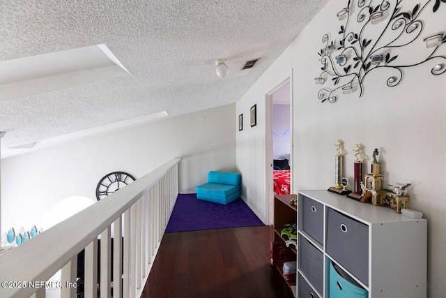 hall featuring dark wood-type flooring and a textured ceiling