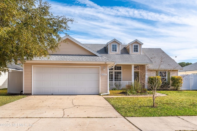 view of front of house featuring a garage, a front yard, and covered porch