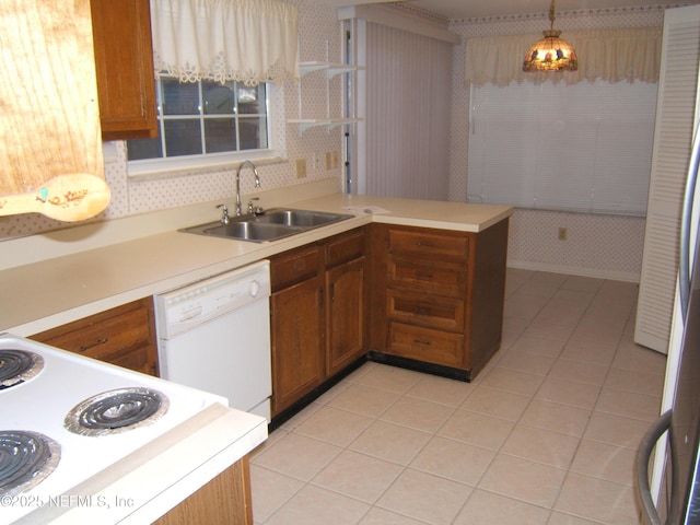 9252 San Jose Blvd Unit 3701, Jacksonville, FL 32257 - kitchen featuring a sink, dishwasher, a peninsula, light tile patterned flooring, and brown cabinetry