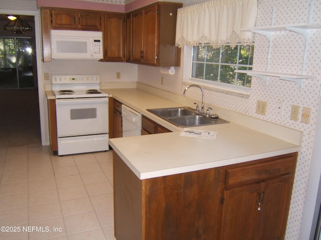 9252 San Jose Blvd Unit 3701, Jacksonville, FL 32257 - kitchen with white appliances, a sink, light countertops, light tile patterned flooring, and a peninsula