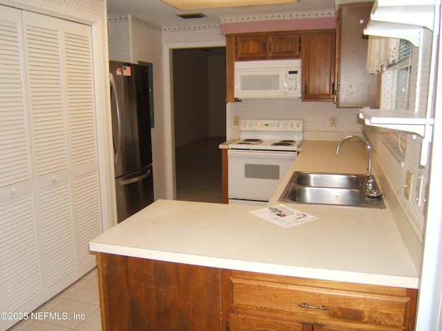9252 San Jose Blvd Unit 3701, Jacksonville, FL 32257 - kitchen with white appliances, a sink, a peninsula, light countertops, and brown cabinets