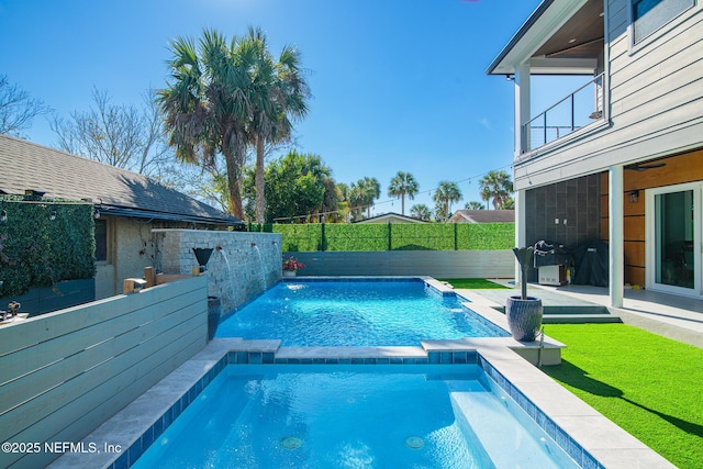 view of pool with pool water feature and a patio