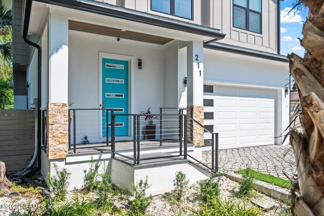 211 Belvedere St, Atlantic Beach, FL 32233 - view of exterior entry with an attached garage, board and batten siding, stone siding, and stucco siding