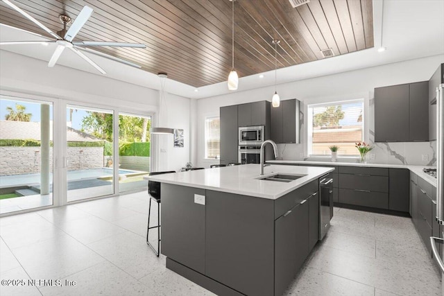 211 Belvedere St, Atlantic Beach, FL 32233 - kitchen with dark aggregate flooring, appliances with stainless steel finishes, a sink, an island with sink, and light countertops