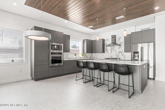 211 Belvedere St, Atlantic Beach, FL 32233 - kitchen with appliances with stainless steel finishes, wood ceiling, dark speckled floor, wall chimney exhaust hood, and gray cabinets
