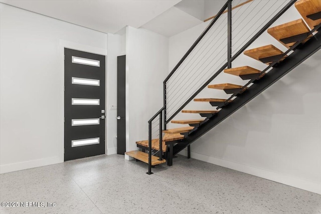 211 Belvedere St, Atlantic Beach, FL 32233 - entrance foyer with speckle patterned floor, stairs, and baseboards