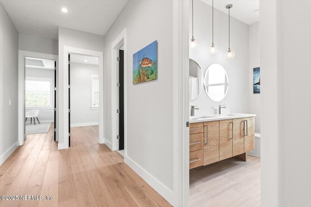 211 Belvedere St, Atlantic Beach, FL 32233 - corridor featuring light wood-type flooring, a sink, baseboards, and recessed lighting