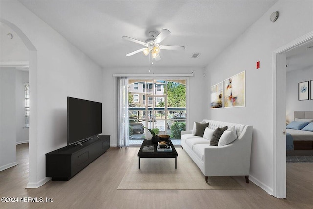 living room with ceiling fan and light hardwood / wood-style flooring