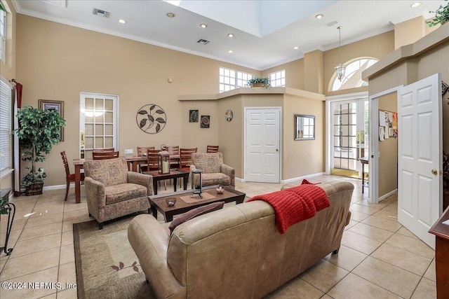 tiled living room featuring a wealth of natural light, a towering ceiling, and ornamental molding