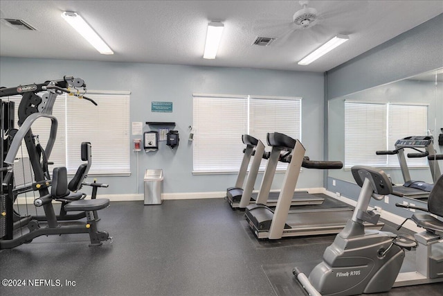 exercise room featuring ceiling fan and a textured ceiling