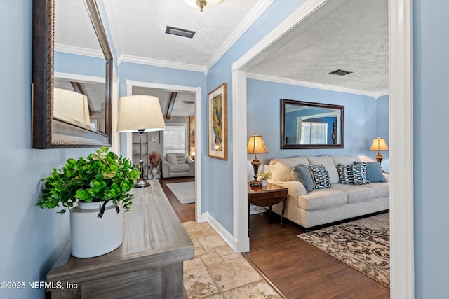 corridor with ornamental molding and a textured ceiling