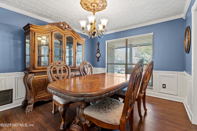 dining space with an inviting chandelier, crown molding, dark hardwood / wood-style flooring, and a textured ceiling