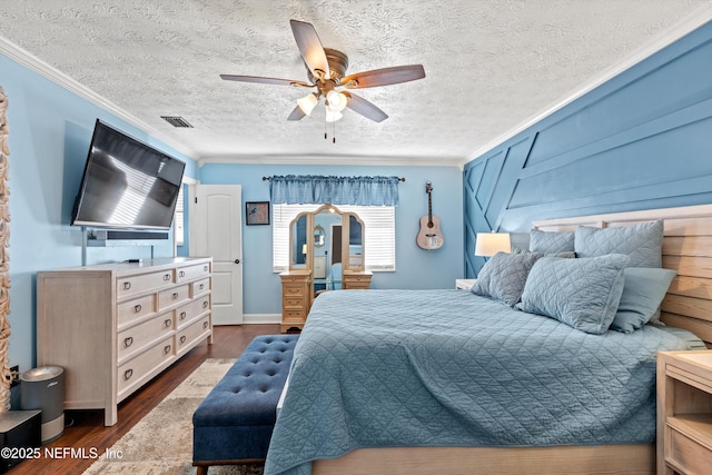 bedroom featuring crown molding, dark wood-type flooring, ceiling fan, and a textured ceiling