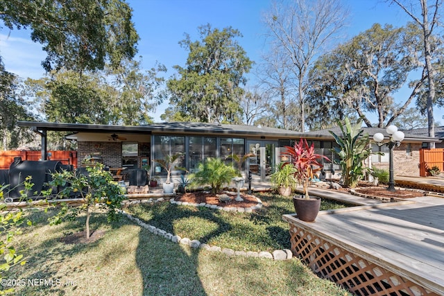 rear view of house featuring a deck and a lawn