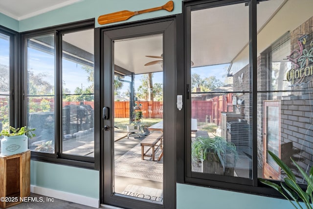 entryway with ornamental molding and a healthy amount of sunlight