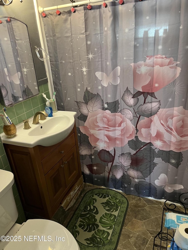 bathroom with vanity, backsplash, and toilet