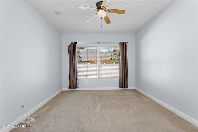 carpeted empty room with ceiling fan and a textured ceiling