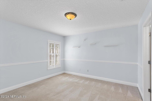 spare room with light carpet and a textured ceiling