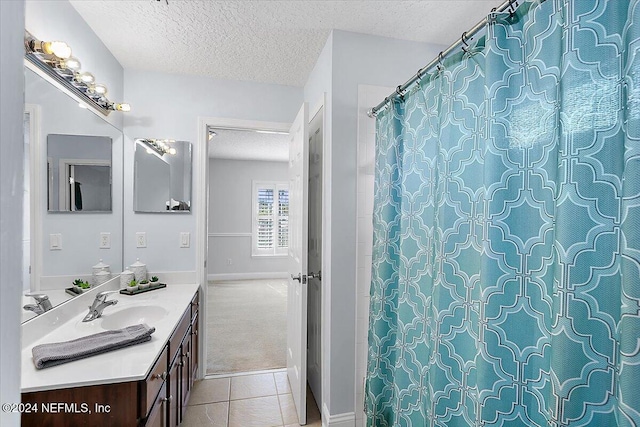 bathroom with a textured ceiling, vanity, and tile patterned flooring